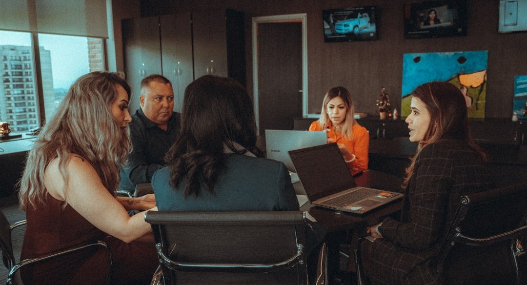 Team of media professionals planning coverage around a table with laptops