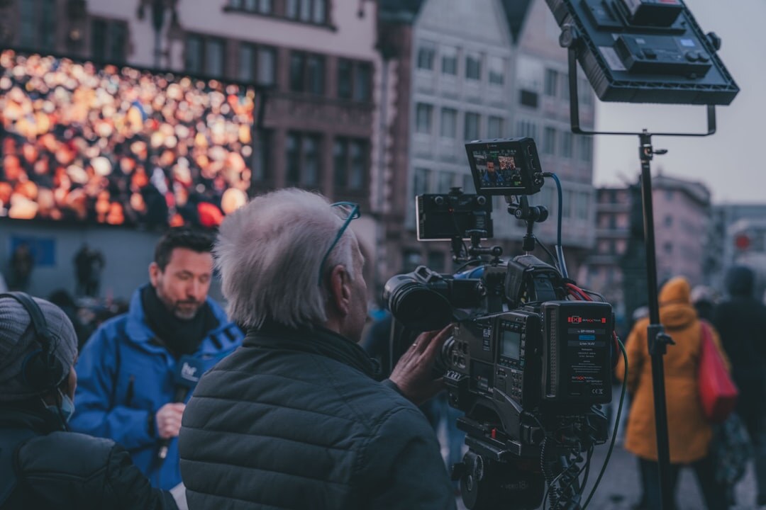 Reporter delivering a live broadcast report in front of a camera crew